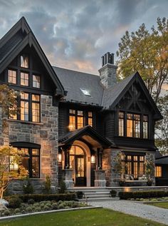 a large house with lots of windows on the front and side of it at dusk