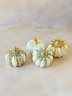 three small white pumpkins sitting on top of a table