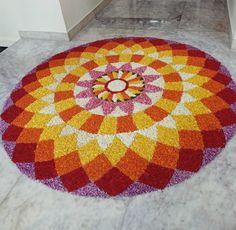 a colorful flower design on the floor in a room with white walls and marble floors