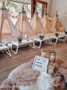 several teepees are set up in a room with candles and signs on the floor