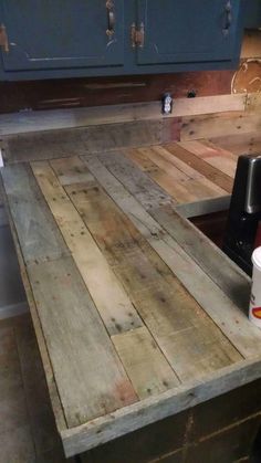 a kitchen counter made out of pallet wood with a coffee cup on the counter