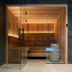 an indoor sauna with stone walls and glass doors