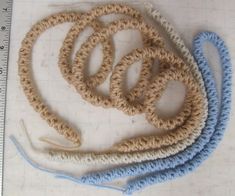 several crocheted objects are laid out on a table with a measuring ruler in front of them