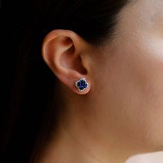 Looking for a pair of elegant and luxurious earrings to add to your fine jewelry collection? Look no further than the Clover Sapphire Studs by Ruchi New York. These stunning studs feature 2.06 carats of vibrant blue sapphires that are surrounded by a halo of sparkling, brilliant cut diamonds, totaling .46 carats. The contrast between the deep blue of the sapphires and the dazzling white of the diamonds is simply breathtaking, and the 18k white gold setting only enhances the beauty of these earri Wedding Earrings With Brilliant Cut Lab-created Sapphire, Brilliant Cut Lab-created Sapphire Earrings For Wedding, Formal Brilliant Cut Lab-created Sapphire Earrings, Fine Jewelry Earrings With Round Cut Sapphire, Fine Jewelry Round Cut Lab-created Sapphire Earrings, Fine Jewelry Earrings With Lab-created Sapphire, Lab-created Sapphire Round Cut Earrings, Fine Jewelry Sapphire Earrings With Brilliant Cut, Formal Sapphire Earrings With Ethical Diamonds