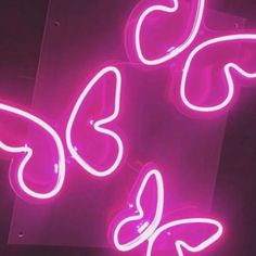 two neon signs that have hearts on them