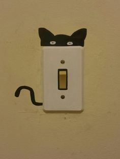 a light switch with a black cat painted on it