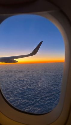 an airplane window looking out at the clouds