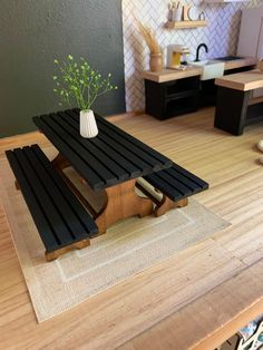 a table with a vase on top of it sitting on a rug in the middle of a kitchen