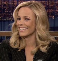 a woman with blonde hair is smiling and wearing a black suit on the tonight show