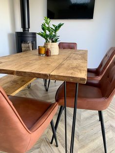 a wooden table with two brown chairs and a potted plant on top of it