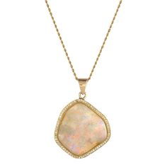 This is part of Chairish’s Fine Jewelry assortment.  Stylish opal & diamond pendant, crafted in 18 karat yellow gold (pendant) and 14 karat yellow gold (chain).    A large natural freeform opal measures 26mm x 24mm and is framed with 75 round brilliant cut diamonds that total an estimated 0.37 carats (estimated at H-I color and VS2-SI1 clarity). The opal is in very good condition and is free of cracks or chips.     The contemporary pendant is designed in a freeform mounting to mirror the shape o Luxury Opal Pendant Necklace, Yellow Gold Opal Pendant Necklace, Elegant Opal Necklace With Large Pendant, Luxury Yellow Gold Opal Necklace, Luxury Gold Opal Necklaces, Luxury Gold Opal Necklace, Contemporary Pendant, Yellow Gold Chain, Yellow Gold Pendants