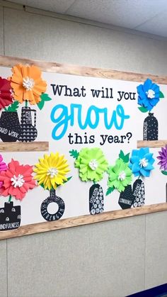 an office cubicle decorated with flowers and bulletin board saying what will you grow this year?