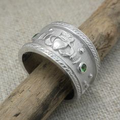 Sterling Silver extra wide Roman Claddagh Wedding Band  12.5 mm wide tapers to 8 mm at back with green CZs. size 9.5 or 10 Made in Ireland Gift Boxed  Assayed in the Dublin Castle Made in Ireland by Boru In Stock! Ships Immediately. This ring is available in sizes 9 to 13 fine them here: https://www.etsy.com/listing/1594354783/wide-sterling-silver-roman-claddagh  Ships free in the USA Ships Free within the USA 21 Day Returns Items must be returned in new unworn condition. Polished May Birthstone Jewelry For Weddings, Wedding Jewelry With Polished Emerald, Heirloom Style May Birthstone Jewelry For Promise, Silver Emerald Ring With Polished Finish For Wedding, Green Hallmarked Round Band Jewelry, Green Hallmarked Jewelry With Round Band, Green Jewelry With Bezel Setting For Wedding, Silver Emerald Ring With Bezel Setting For Wedding, Silver Jewelry With May Birthstone In Round Band Shape