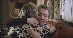 two women hugging each other while sitting on a couch