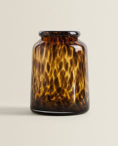 a brown and black glass vase sitting on top of a table