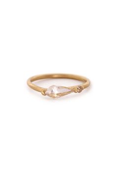 an image of a gold ring with a white stone in the middle and two small diamonds on