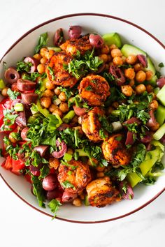 a white bowl filled with vegetables and shrimp