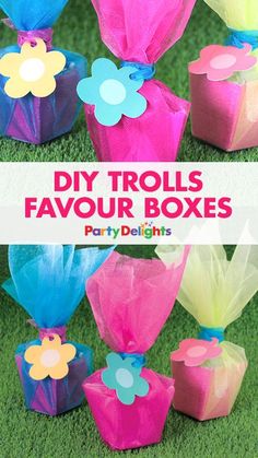 colorful paper flowers are placed in small boxes on the grass with text overlay that reads diy floral favors