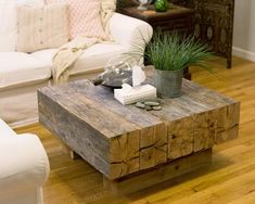 a living room with white couches and a wooden coffee table in the center area