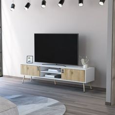 a flat screen tv sitting on top of a white entertainment center in a living room