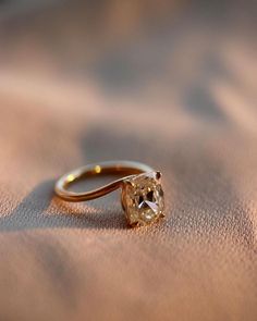 a close up of a diamond ring on a surface with the light shining through it