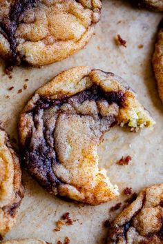 chocolate chip cookies with crumbs and powdered sugar on top, sitting on a baking sheet