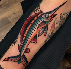 a colorful fish tattoo on the arm and leg with an orange stripe around it's tail