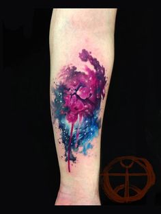 a colorful ink splattered heart on the right arm and left leg tattoo artist