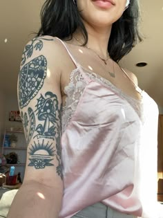 a woman with tattoos on her arm posing for the camera