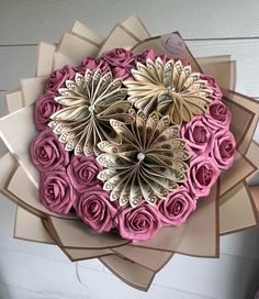 a bouquet of pink and gold paper flowers on top of each other with butterflies in the middle