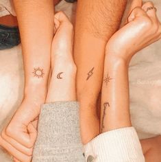 two people with matching tattoos on their arms and legs, one holding the other's hand