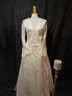 a white dress on a mannequin next to a lamp