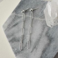 These long dangle earrings feature trendy sterling silver paper clip chain with a sleek modern look. The rectangle links measure 12mm long and about 3mm wide and the chain has a nice bright polish. It is made of Hill Tribe Silver which has a higher silver content than sterling (97% to 92.5%) and features a beautiful luster. The chain is paired with 4mm sterling silver posts for a minimalist design that goes with everything. The earrings come in two lengths - the shorter length is about 1.5 inche Modern Link-style Earrings With Box Chain, Minimalist Paperclip Chain Dangle Earrings, Silver Box Chain Dangle Linear Earrings, Silver Dangle Linear Earrings With Box Chain, Minimalist Silver Box Chain Earrings, Modern Linear Earrings With Adjustable Chain, Minimalist Sterling Silver Earrings With Box Chain, Minimalist Sterling Silver Box Chain Earrings, Everyday Paperclip Chain Dangle Earrings