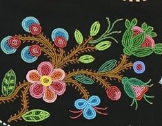 an embroidered black cloth with colorful flowers and leaves