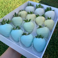 there are strawberries in the box with green leaves on them and white paper balls