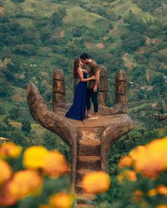 a man and woman kissing on top of a statue