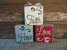 three wooden blocks with the words faith, hope and love painted on them