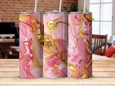 three pink and gold marbled canisters sitting on a wooden table