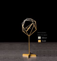 a gold sculpture with geometric shapes on it and the words silver in front of it