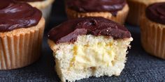 cupcakes with chocolate frosting sitting on top of a blue cloth covered table