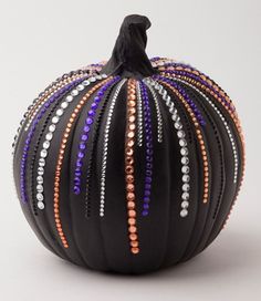 a black pumpkin decorated with multi - colored beads