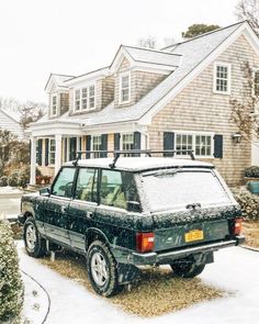 an suv parked in front of a house covered in snow