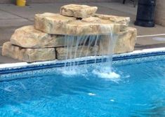 a small pool with water coming out of it and some rocks on the side of it