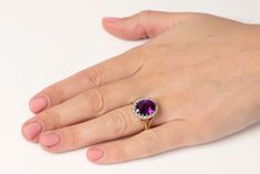 For Sale on 1stDibs - This beautiful dress ring features a natural amethyst in the centre. The colour is a beautiful deep purple and it weighs 4.50 carat. The halo of diamonds Classic Purple Diamond Wedding Ring, Classic Purple Diamond Ring With Halo Setting, Classic Purple Diamond Ring For Formal Occasions, Formal Purple Diamond Ring With Halo Setting, Elegant Formal Amethyst Ring With Halo, Formal Halo Diamond Amethyst Ring, Elegant Formal Amethyst Halo Ring, Purple Heirloom Diamond Ring For Formal Occasions, Heirloom Purple Diamond Ring For Formal Occasions