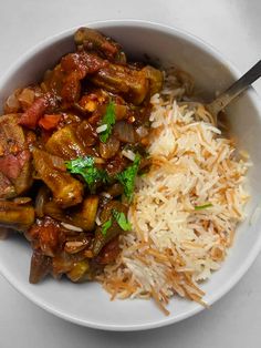 a white bowl filled with rice and meat