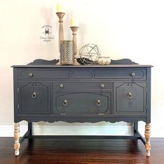 a black dresser with candles on top of it