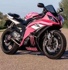 a pink and black motorcycle parked on the street