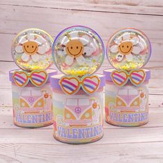 three small tins filled with candy sitting on top of a wooden table