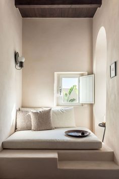 a white couch sitting under a window in a living room