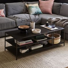 a living room with a couch, coffee table and bookshelf in the corner